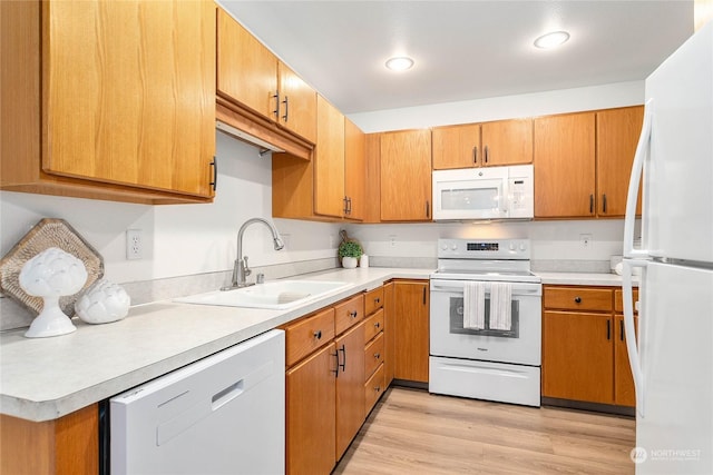 kitchen featuring light wood-type flooring, white appliances, and sink