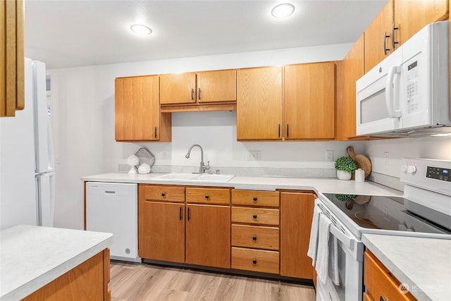 kitchen with white appliances, light hardwood / wood-style flooring, and sink