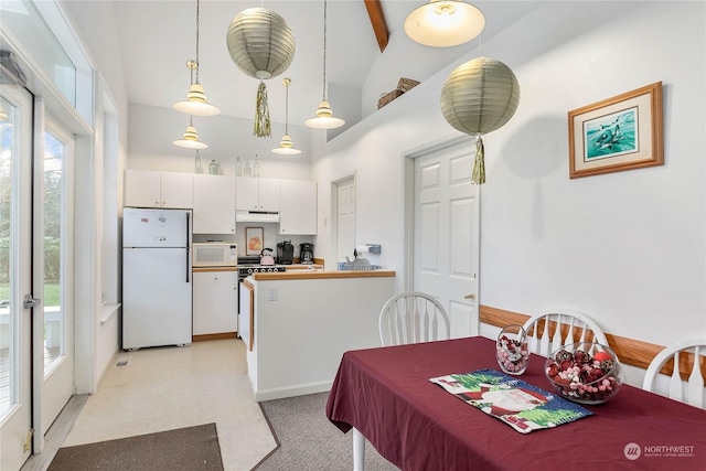 carpeted dining space with vaulted ceiling with beams