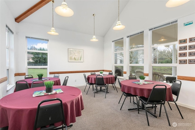 carpeted dining room with beam ceiling, high vaulted ceiling, and a healthy amount of sunlight