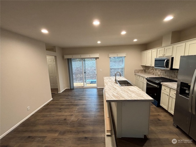 kitchen with a center island with sink, dark hardwood / wood-style flooring, white cabinetry, and appliances with stainless steel finishes