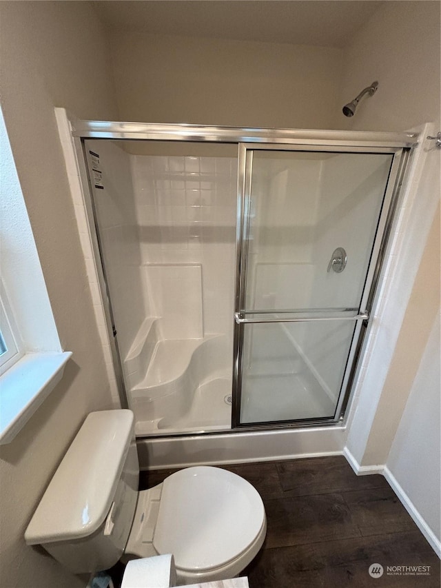 bathroom featuring wood-type flooring, toilet, and walk in shower