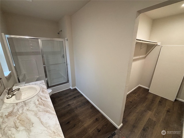 bathroom with hardwood / wood-style floors, vanity, and an enclosed shower