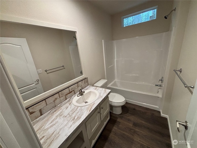 full bathroom with bathtub / shower combination, vanity, hardwood / wood-style flooring, and toilet