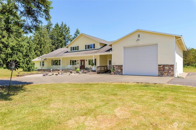 view of front of house with covered porch, a garage, and a front lawn