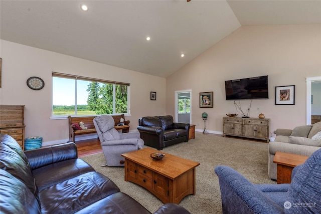 living room featuring light colored carpet, high vaulted ceiling, and a healthy amount of sunlight