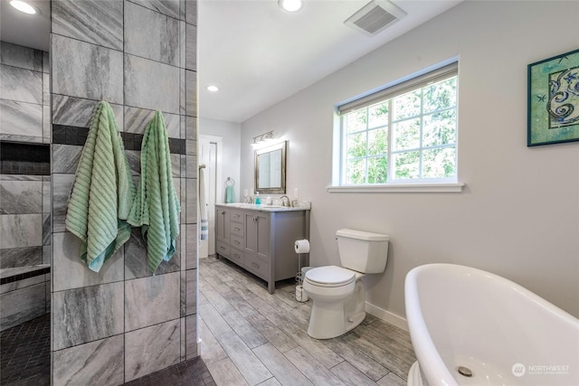 bathroom with vanity, hardwood / wood-style flooring, toilet, and a bathing tub