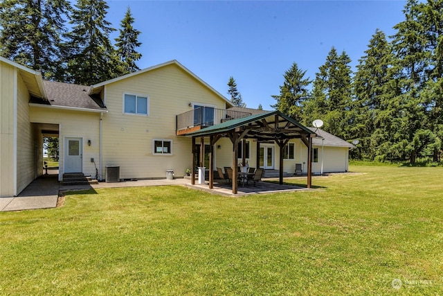 back of house with a lawn, central AC unit, a patio area, and a balcony