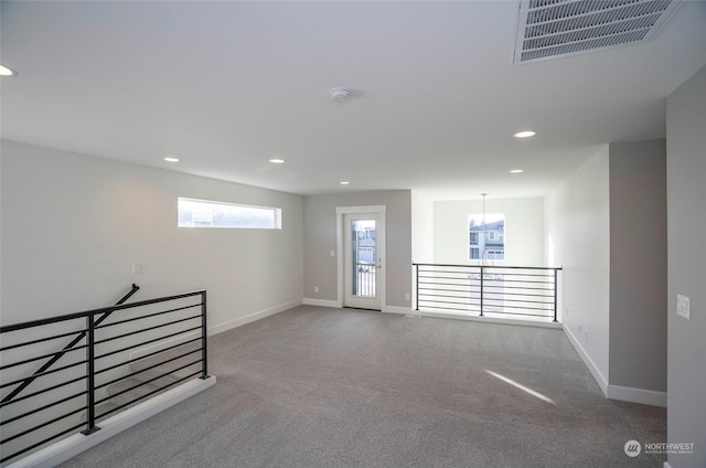 unfurnished room featuring carpet flooring and a notable chandelier