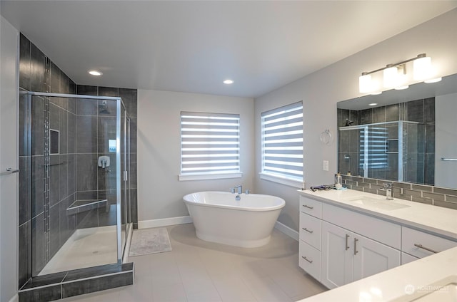 bathroom with vanity, backsplash, and independent shower and bath