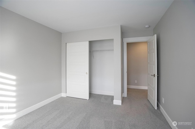 unfurnished bedroom featuring carpet floors and a closet