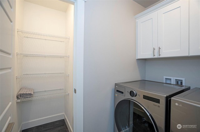 clothes washing area featuring cabinets and separate washer and dryer