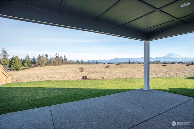 view of yard with a mountain view, a rural view, and a patio area