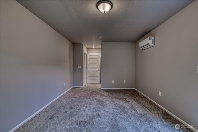 carpeted empty room featuring an AC wall unit and a textured ceiling