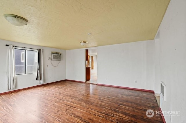 319 4th Ave, Mabton, WA 98935 - spare room featuring a wall unit AC and hardwood / wood-style flooring