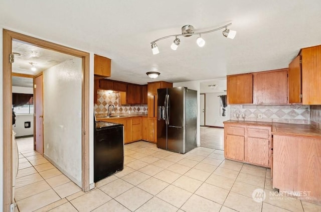 319 4th Ave, Mabton, WA 98935 - kitchen featuring sink, black stove, backsplash, stainless steel fridge, and light tile patterned floors