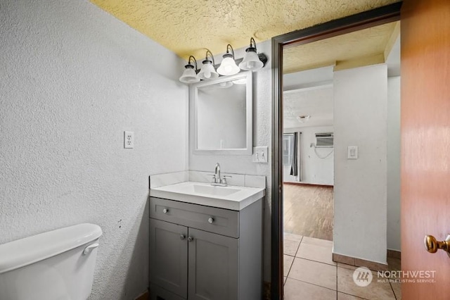 319 4th Ave, Mabton, WA 98935 - bathroom with toilet, vanity, a textured ceiling, and hardwood / wood-style flooring