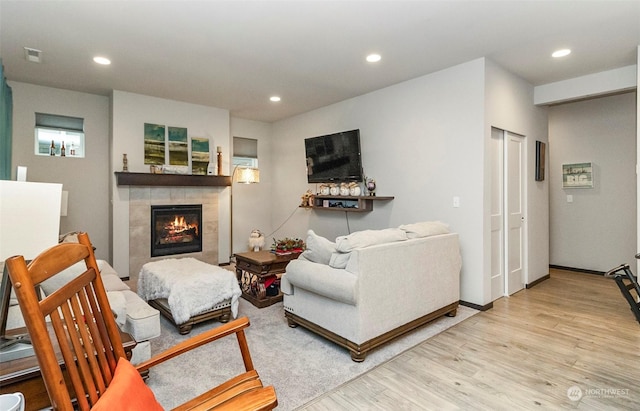 living room with light hardwood / wood-style floors and a fireplace