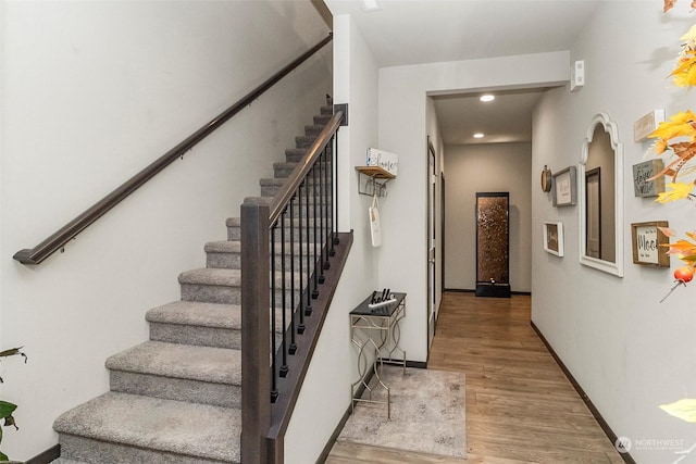 staircase with hardwood / wood-style floors