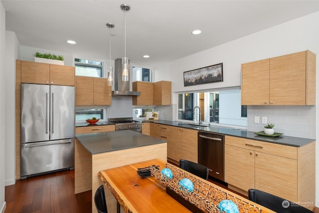 kitchen featuring high quality appliances, sink, wall chimney exhaust hood, dark hardwood / wood-style floors, and decorative backsplash