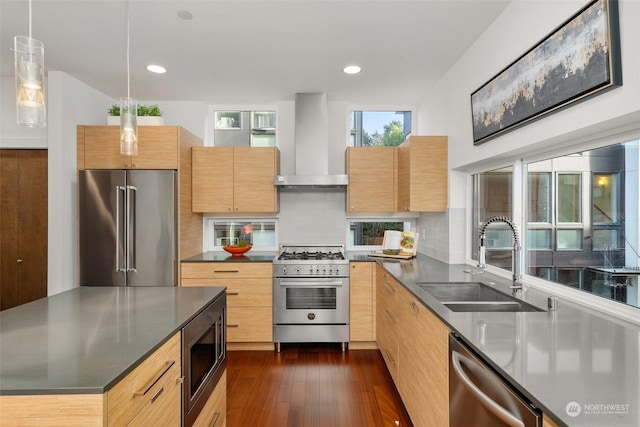 kitchen featuring sink, hanging light fixtures, dark wood-type flooring, wall chimney range hood, and high end appliances