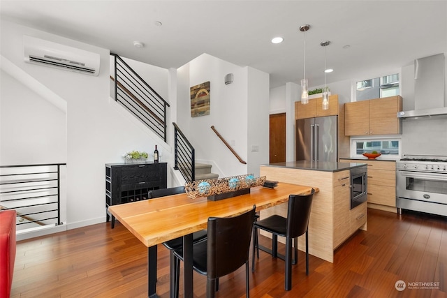 kitchen featuring a wall mounted AC, dark hardwood / wood-style flooring, wall chimney exhaust hood, and premium appliances