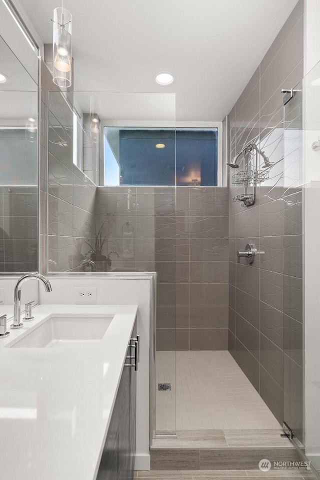 bathroom featuring hardwood / wood-style floors, vanity, and a shower with shower door