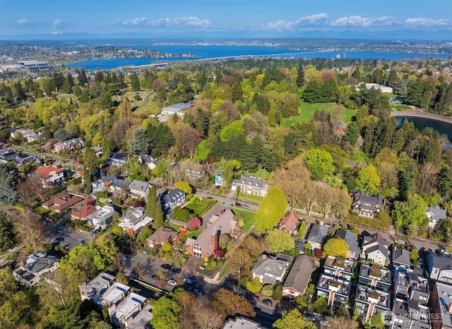 drone / aerial view featuring a forest view, a water view, and a residential view