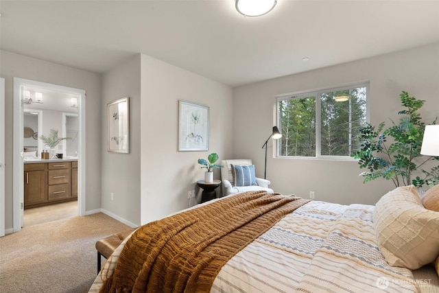 bedroom featuring light carpet, connected bathroom, and baseboards