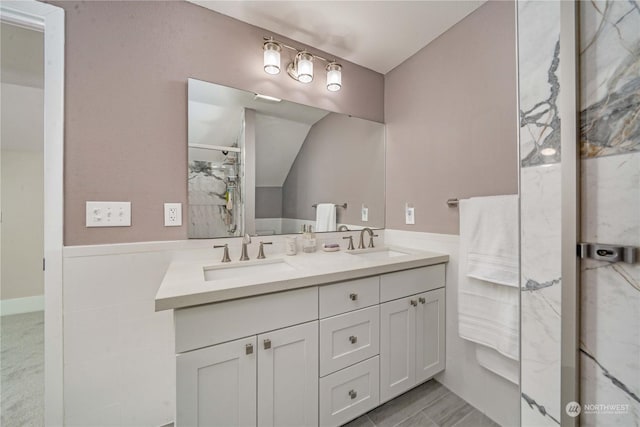 bathroom featuring vanity, walk in shower, and lofted ceiling