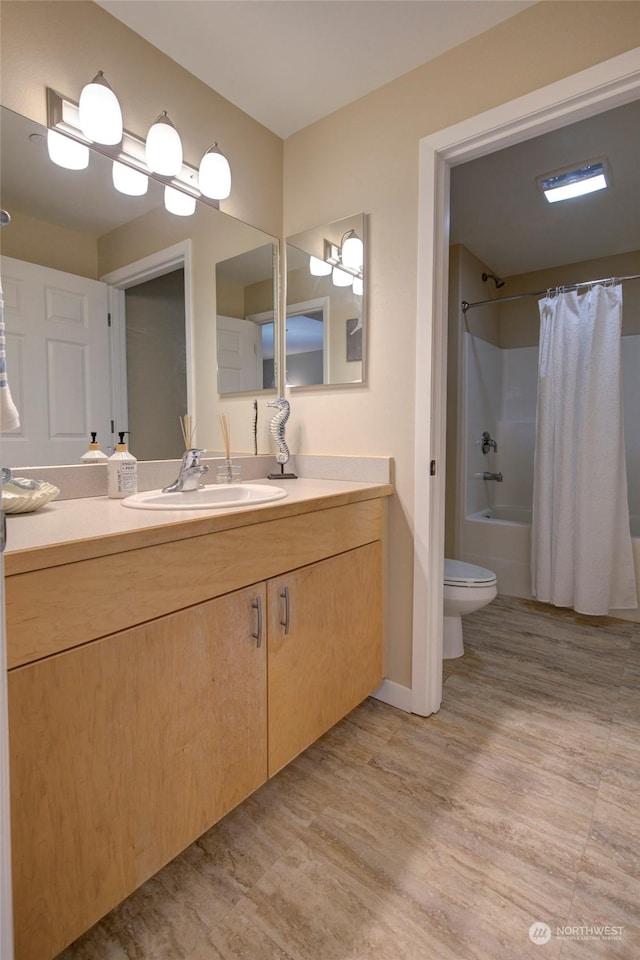 full bathroom with hardwood / wood-style floors, vanity, toilet, and shower / bath combo with shower curtain