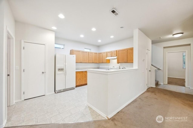 kitchen with white refrigerator with ice dispenser, stove, light colored carpet, and kitchen peninsula