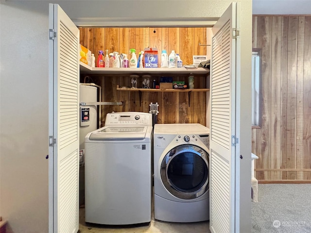 laundry area with independent washer and dryer and wood walls