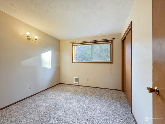 carpeted spare room featuring a textured ceiling