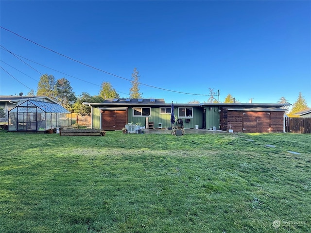 rear view of property featuring an outdoor structure and a lawn