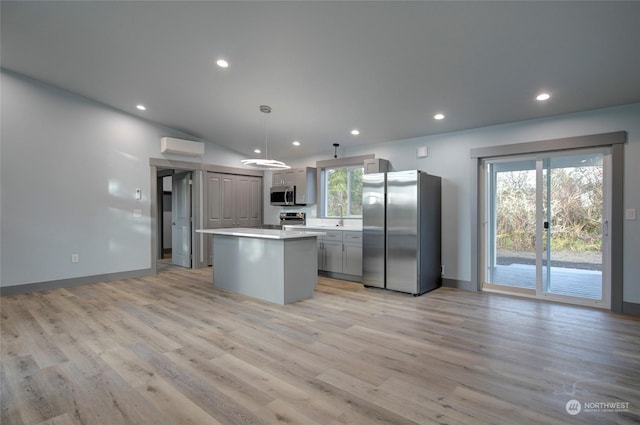 kitchen featuring pendant lighting, appliances with stainless steel finishes, a center island, a healthy amount of sunlight, and gray cabinetry