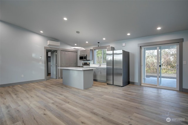 kitchen featuring pendant lighting, appliances with stainless steel finishes, a center island, gray cabinetry, and a wall mounted air conditioner