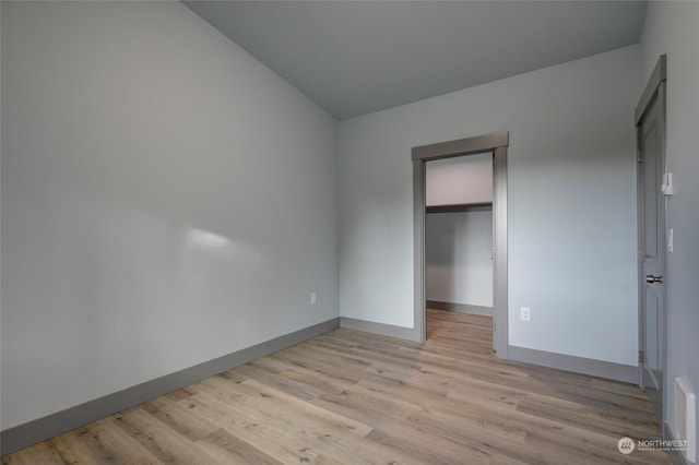 unfurnished bedroom with a closet and light wood-type flooring