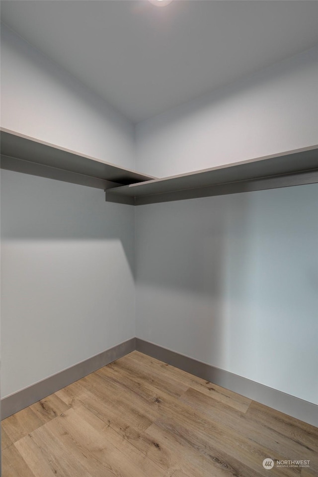 walk in closet with light hardwood / wood-style floors