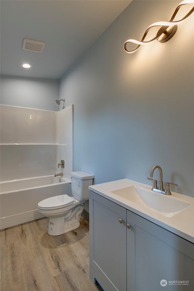 full bathroom with hardwood / wood-style flooring, shower / tub combination, toilet, and vanity