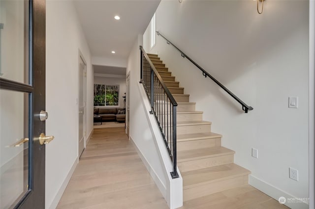 staircase with hardwood / wood-style floors