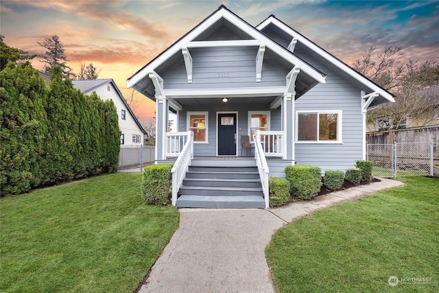 view of front of house with a yard and a porch