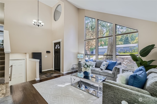 living room with dark hardwood / wood-style flooring, high vaulted ceiling, and an inviting chandelier