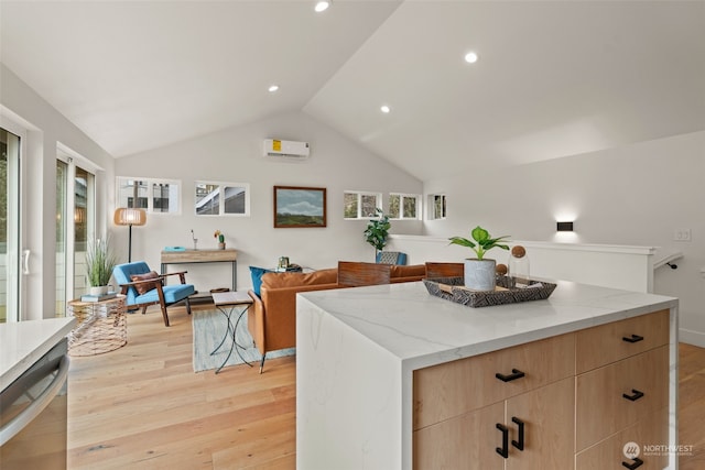 kitchen with light brown cabinets, lofted ceiling, light hardwood / wood-style flooring, a kitchen island, and light stone counters