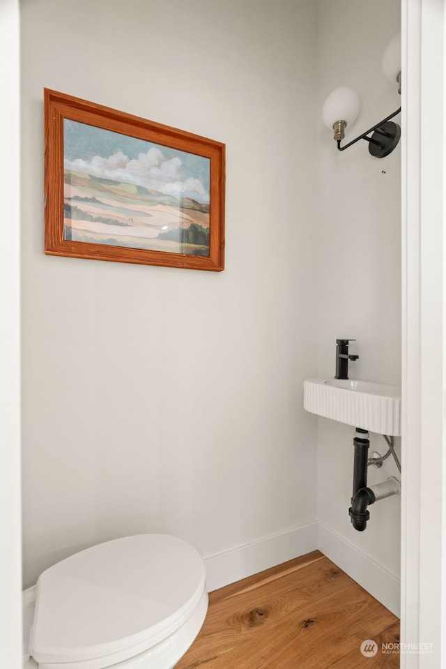 bathroom with hardwood / wood-style floors and toilet