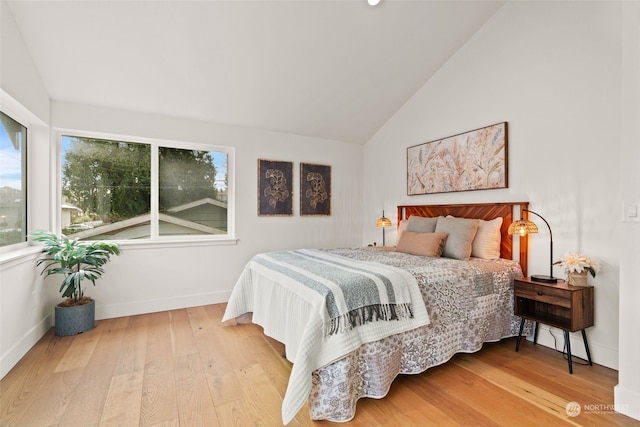 bedroom with wood-type flooring, multiple windows, and lofted ceiling