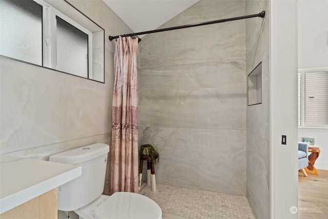 bathroom with a shower with shower curtain, hardwood / wood-style flooring, toilet, and tile walls