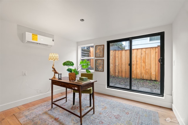 office space featuring a wall unit AC and light hardwood / wood-style flooring