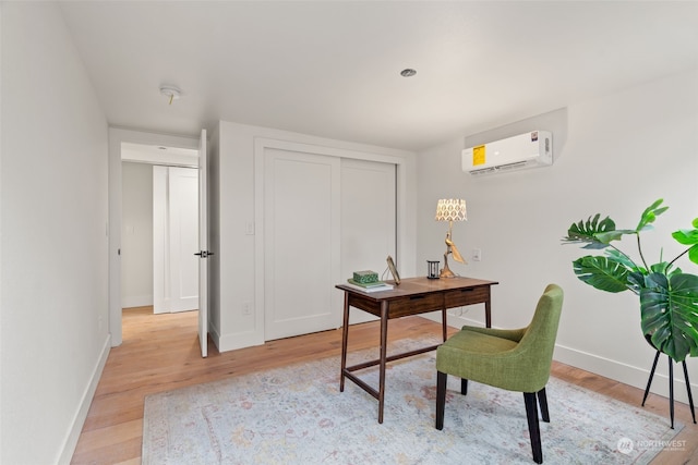 office featuring an AC wall unit and light hardwood / wood-style flooring