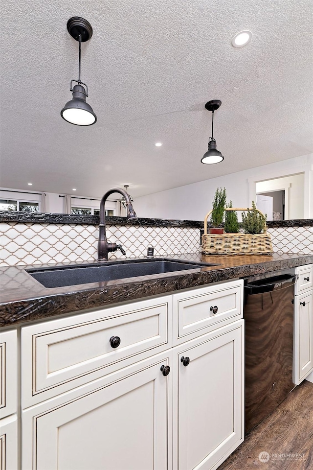 kitchen with backsplash, dark hardwood / wood-style flooring, decorative light fixtures, and sink